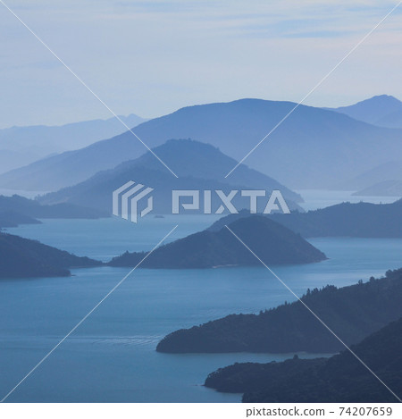 Outlines of hills and bay on a hazy day in New Zealand. 74207659