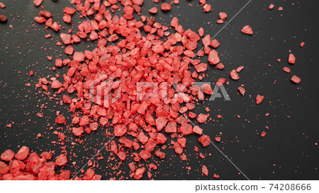 Salt isolated on a black background. A pile of red salt. Large crystalline salt. Salt isolated on a black background. A pile of red salt. Large crystalline salt. 74208666
