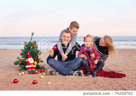 Christmas portrait of happy family on the beach 74209702