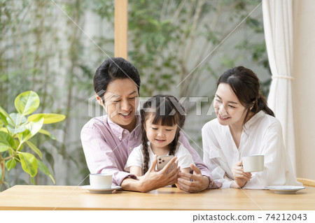 Parents and children looking at smartphones together Parents and children looking at smartphones together 74212043