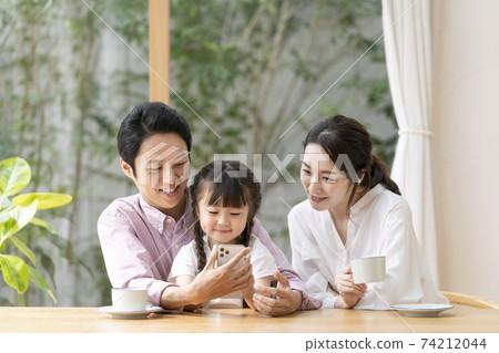Parents and children looking at smartphones together Parents and a 6-year-old girl Parents and children looking at smartphones together Parents and a 6-year-old girl 74212044