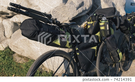 The mixed terrain cycle touring bike with bikepacking. The trip on multitrack bike, outdoor road in mountain snow capped. 74214391