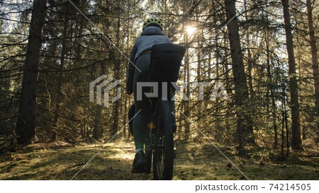 The woman travel on mixed terrain cycle touring with bike bikepacking. The traveler journey with bicycle bags. Magic forest park. The woman travel on mixed terrain cycle touring with bike bikepacking. The traveler journey with bicycle bags. Magic forest park. 74214505