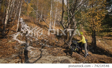 The woman travel on mixed terrain cycle touring with bikepacking. The traveler journey with bicycle bags. Sport tourism bikepacking. The woman travel on mixed terrain cycle touring with bikepacking. The traveler journey with bicycle bags. Sport tourism bikepacking. 74214546