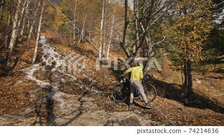 The man travel on mixed terrain cycle touring with bikepacking. The traveler journey with bicycle bags. Sport tourism bikepacking. The man travel on mixed terrain cycle touring with bikepacking. The traveler journey with bicycle bags. Sport tourism bikepacking. 74214636
