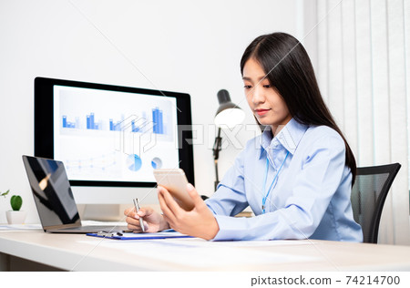 Asian women sit at their desks and calculate financial graphs showing results about their investments, plan a successful business growth process Asian women sit at their desks and calculate financial graphs showing results about their investments, plan a successful business growth process 74214700