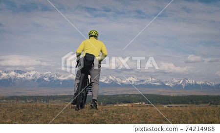 The man travel on mixed terrain cycle touring with bikepacking. The traveler journey with bicycle bags. Sport tourism bikepacking. The man travel on mixed terrain cycle touring with bikepacking. The traveler journey with bicycle bags. Sport tourism bikepacking. 74214988