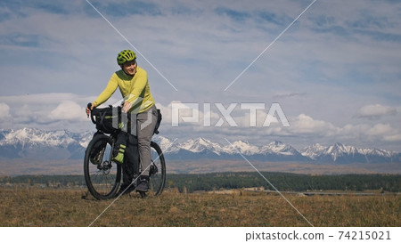 The man travel on mixed terrain cycle touring with bikepacking. The traveler journey with bicycle bags. Sport tourism bikepacking. The man travel on mixed terrain cycle touring with bikepacking. The traveler journey with bicycle bags. Sport tourism bikepacking. 74215021