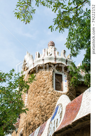 Stone walls and tiled ornaments and cylindrical stone buildings in Park Guell, Barcelona, Spain 74222152