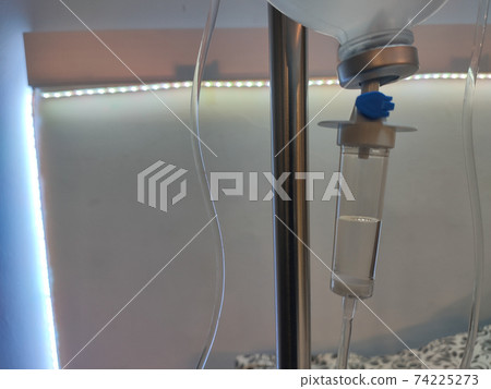 Hospital dropper with saline solution. White background with a led strip. Horizontal photography. Hospital dropper with saline solution. White background with a led strip. Horizontal photography. 74225273