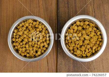 Dry cat food in metal bowl on wooden background. Studio Photo Dry cat food in metal bowl on wooden background. Studio Photo 74226057