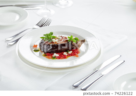 Half baked eggplants with meat, cheese and tomatoes on white background. Banquet festive dishes. Gourmet restaurant menu. White background. 74226122