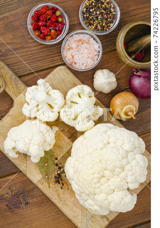 Head of cabbage fresh organic cauliflower on wooden background, spices. Studio Photo Head of cabbage fresh organic cauliflower on wooden background, spices. Studio Photo 74226795