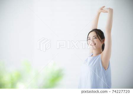 Woman waking up stretching Woman waking up stretching 74227720