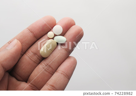 Close up of man hand holding pills with copy space  74228982
