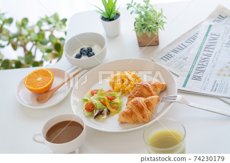 Breakfast croissant, scrambled eggs and salad, yogurt with blueberries, coffee, green juice, orange Breakfast croissant, scrambled eggs and salad, yogurt with blueberries, coffee, green juice, orange 74230179