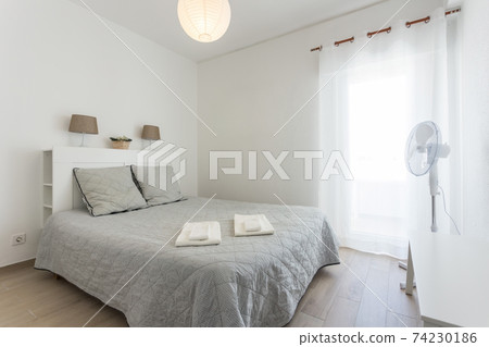 Minimalistic bedroom in bright colors and white walls. European style. 74230186