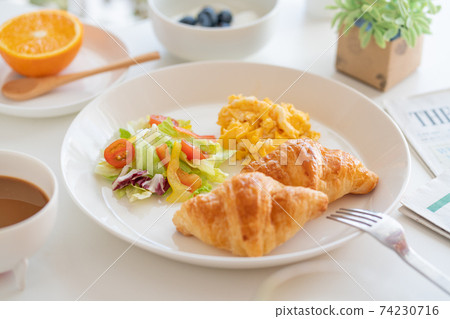 Breakfast croissant, scrambled eggs and salad, yogurt with blueberries, coffee, green juice, orange Breakfast croissant, scrambled eggs and salad, yogurt with blueberries, coffee, green juice, orange 74230716