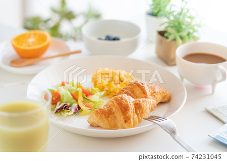 Breakfast croissant, scrambled eggs and salad, yogurt with blueberries, coffee, green juice, orange Breakfast croissant, scrambled eggs and salad, yogurt with blueberries, coffee, green juice, orange 74231045