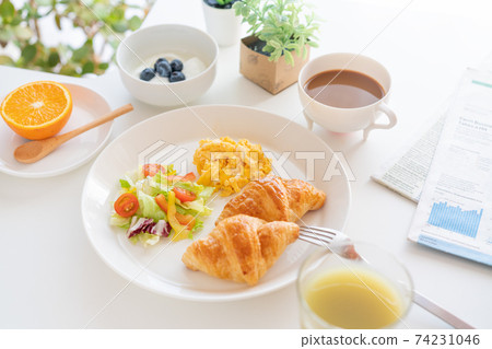Breakfast croissant, scrambled eggs and salad, yogurt with blueberries, coffee, green juice, orange Breakfast croissant, scrambled eggs and salad, yogurt with blueberries, coffee, green juice, orange 74231046