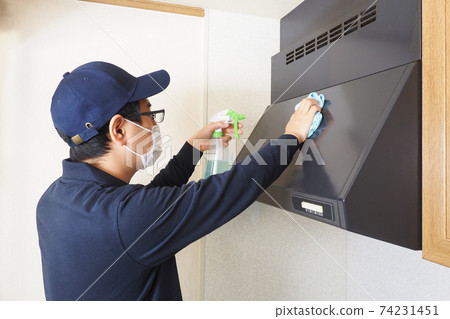 House cleaning male worker cleaning the ventilation fan of the gas stove House cleaning male worker cleaning the ventilation fan of the gas stove 74231451