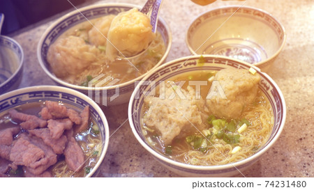 Eating Hong Kong Cantonese wonton beef and meat ball soup noodle Eating Hong Kong Cantonese wonton beef and meat ball soup noodle 74231480