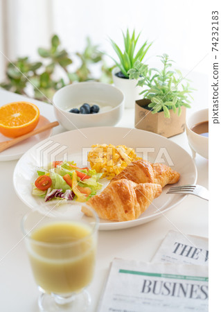 Breakfast croissant, scrambled eggs and salad, yogurt with blueberries, coffee, green juice, orange 74232183