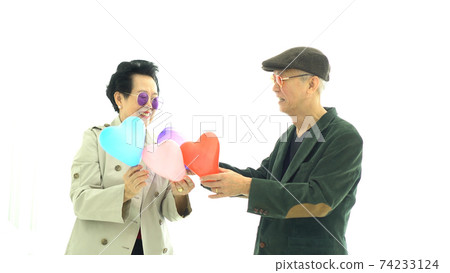 Asian elder couple holding hearts in winter fashion cloth happy romantic life Asian elder couple holding hearts in winter fashion cloth happy romantic life 74233124
