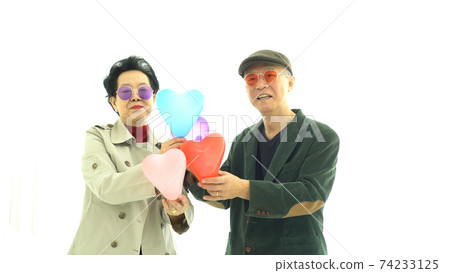 Asian elder couple holding hearts in winter fashion cloth happy romantic life Asian elder couple holding hearts in winter fashion cloth happy romantic life 74233125