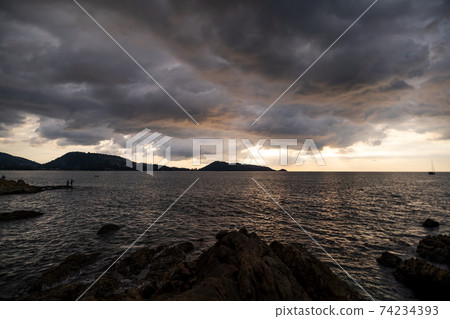 Dark storm cloud Rain clouds over sea in sunset or sunrise sky Dramatic black cloudscape in bad weather day Horrible weather day 74234393