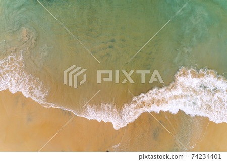 Aerial top view tropical beach sea wave splashing on sandy shore white sea foam Aerial top view tropical beach sea wave splashing on sandy shore white sea foam 74234401