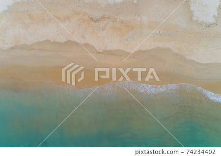 Aerial top view tropical beach sea wave splashing on sandy shore white sea foam Aerial top view tropical beach sea wave splashing on sandy shore white sea foam 74234402