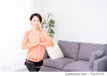 Middle woman doing yoga at home Middle woman doing yoga at home 74235315