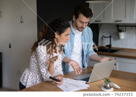 Family couple checking bank account confused with going over budget 74237353