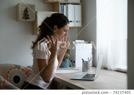 Shocked young lady unable to work online having slow internet 74237405