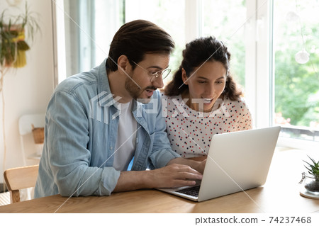 Surprised married couple read email with profitable proposal from laptop 74237468