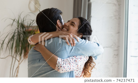 Excited wife holding beloved husband in arms grateful for support 74237471