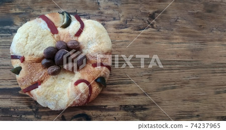 Rosca or Roscon de Reyes, dessert to celebrate Epiphany or Three Kings Day. Christmas cake on rustic wooden background with copy space 74237965
