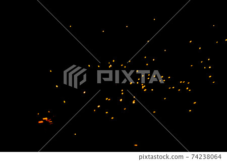 Particles of burning embers fly and glow isolated in the night sky. Natural yellow-hot sparks of fire on a black background, bright yellow bokeh from the fire. 74238064