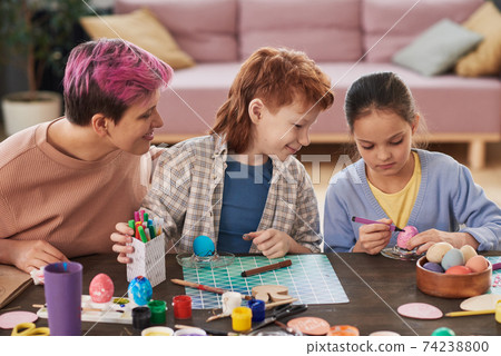 Mother with children painting eggs 74238800
