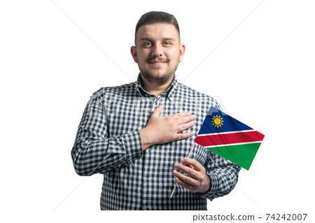 White guy holding a flag of Namibia and holds his hand on his heart isolated on a white background With love to Namibia 74242007