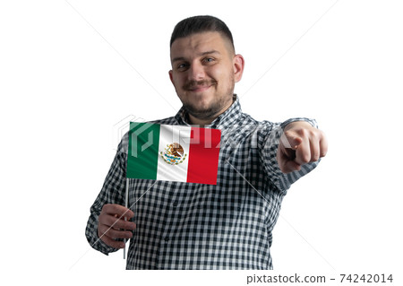 White guy holding a flag of Mexico and points forward in front of him isolated on a white background 74242014