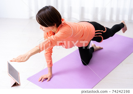 中年女人在家做在線瑜伽 中年女人在家做在線瑜伽 74242198