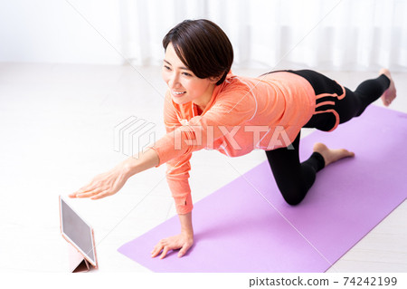 中年女人在家做在線瑜伽 中年女人在家做在線瑜伽 74242199