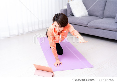 中年女人在家做在線瑜伽 74242200