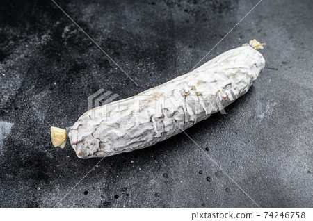 Spanish dry cured salchichon salami. Black background. Top view Spanish dry cured salchichon salami. Black background. Top view 74246758