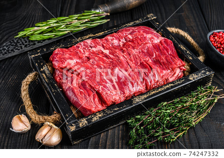 Raw fresh beef brisket cut meat with herbs in a wooden tray. Black wooden background. Top view Raw fresh beef brisket cut meat with herbs in a wooden tray. Black wooden background. Top view 74247332