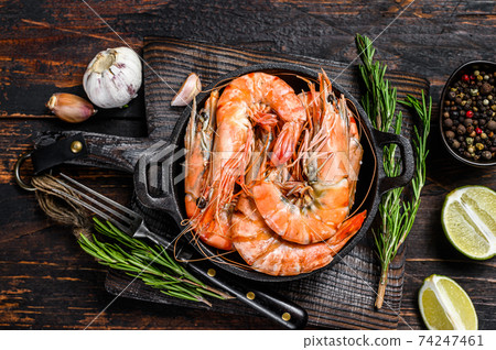Red Tiger shrimps Prawns in a pan. Dark wooden background. Top view Red Tiger shrimps Prawns in a pan. Dark wooden background. Top view 74247461