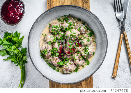 Mince meat meatballs with cream sauce on a plate. White wooden background. Top view 74247478