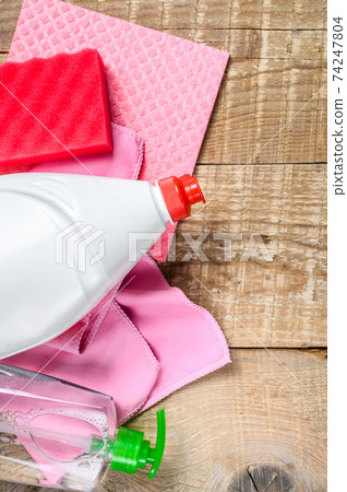 Pink domestic supplies for spring cleaning service. wooden background. Top view Pink domestic supplies for spring cleaning service. wooden background. Top view 74247804